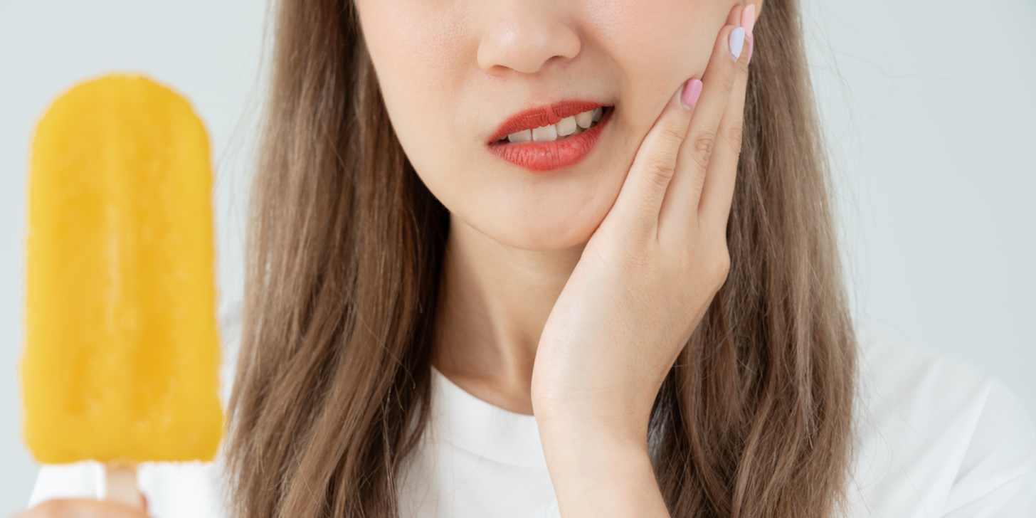 Donna mangia un gelato e soffre di mal di denti